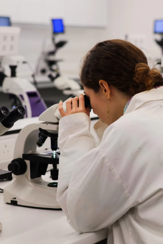 Researcher examining a sample under a microscope